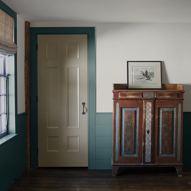 A hallway with white-painted walls and blue-painted wainscoting and trim.
